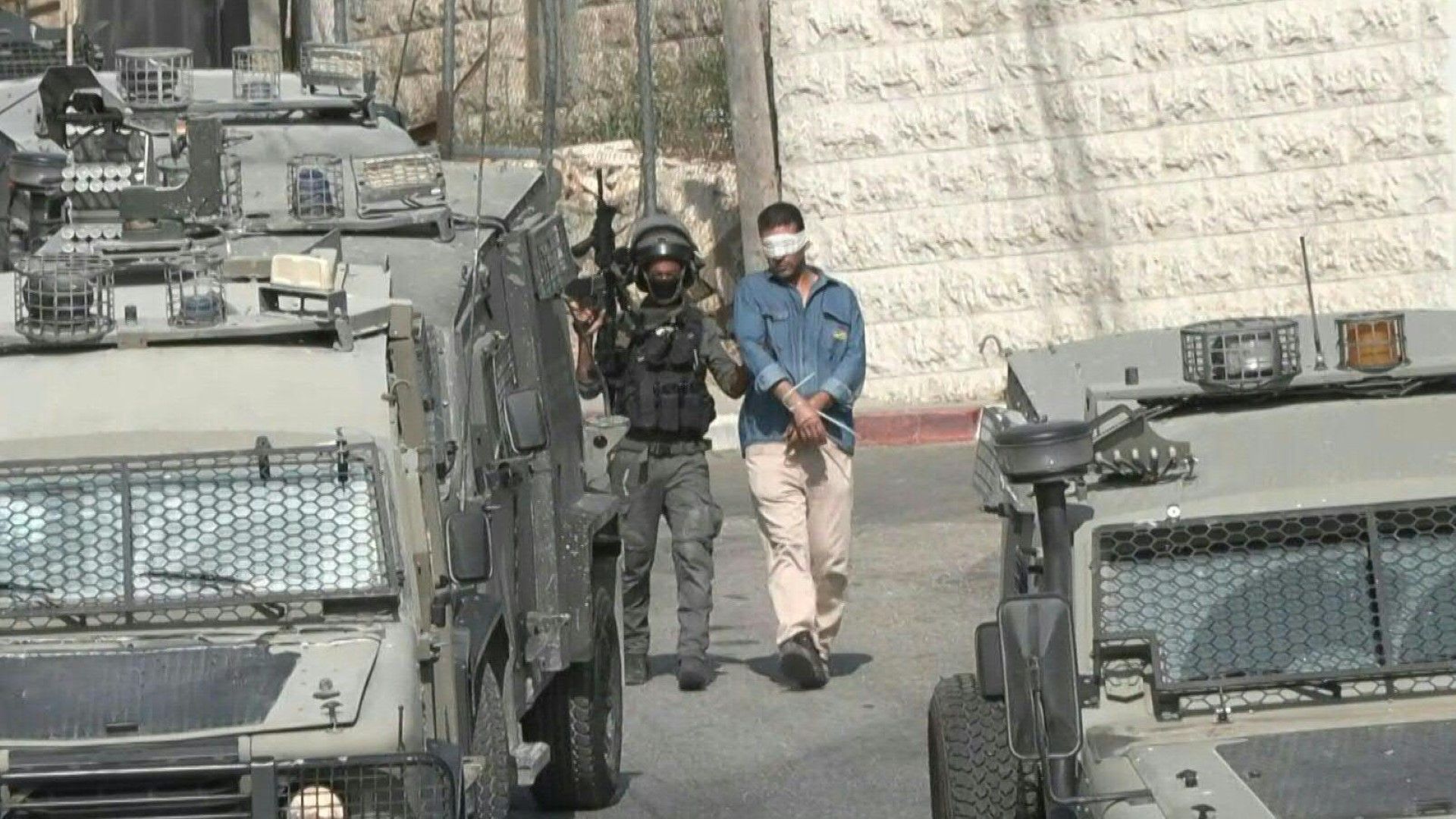 Israeli forces detain a Palestinian during Ramallah raid