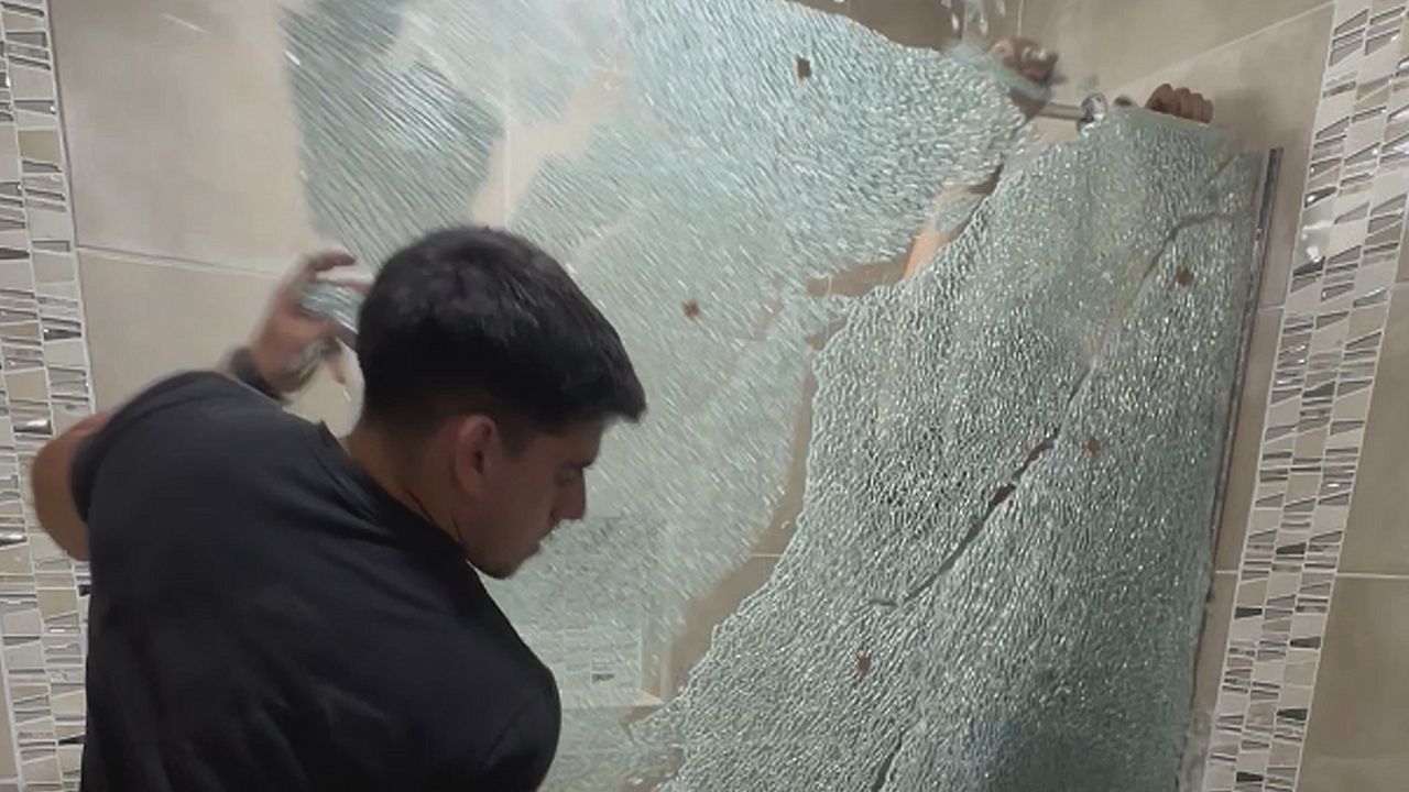 Männer bauen Glasscheibe in Dusche ein – dann passiert es
