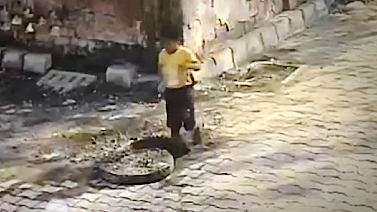 Distracted boy rescued by locals after falling into uncovered sewer in India
