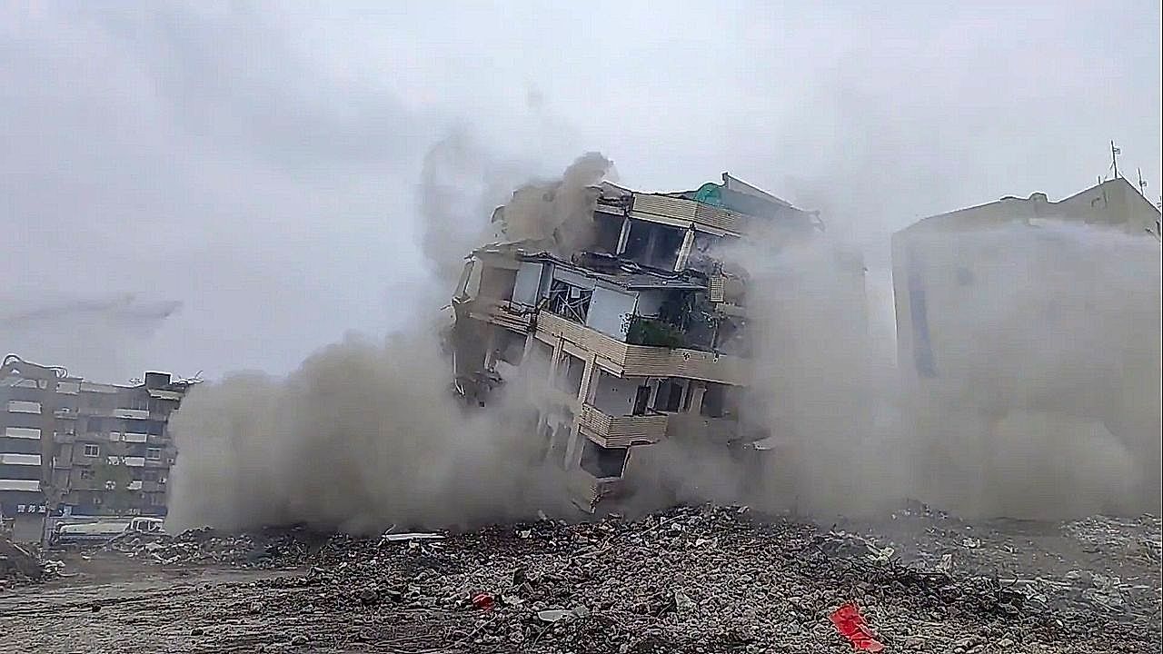 Excavator brings down building in controlled demolition