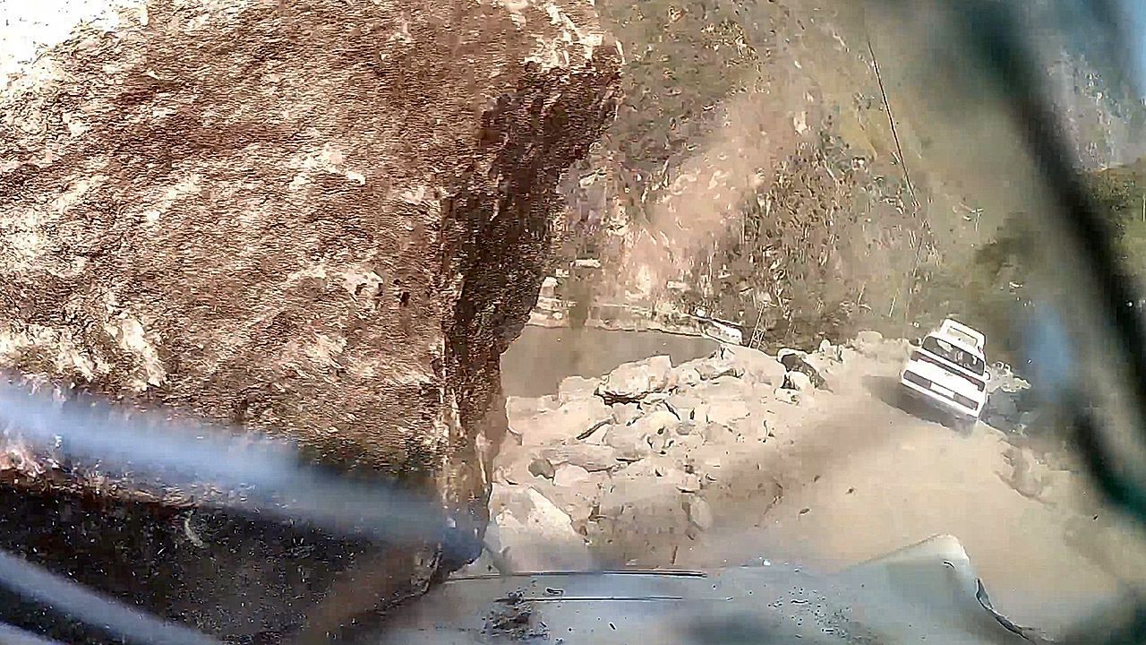 Massive boulder rolls across car's hood on mountain road in India