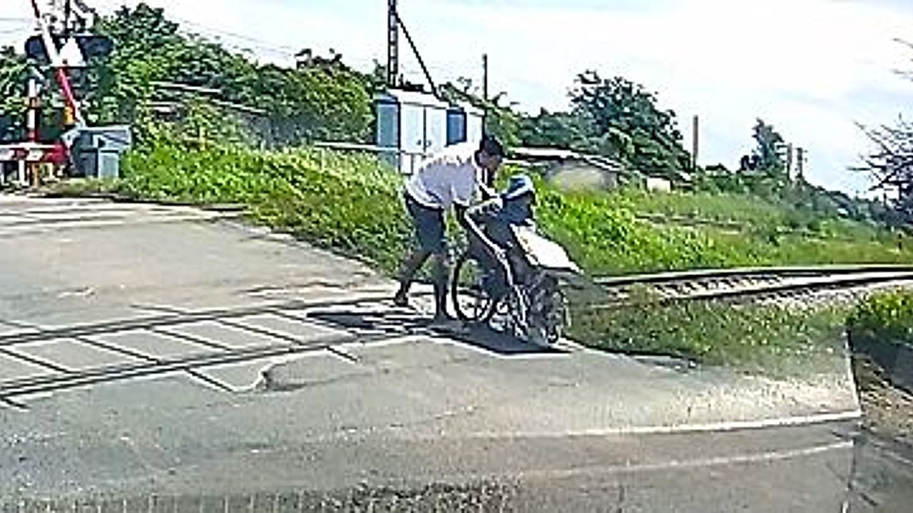 Video: Driver leaps out of car to rescue wheelchair vendor stuck on railway crossing