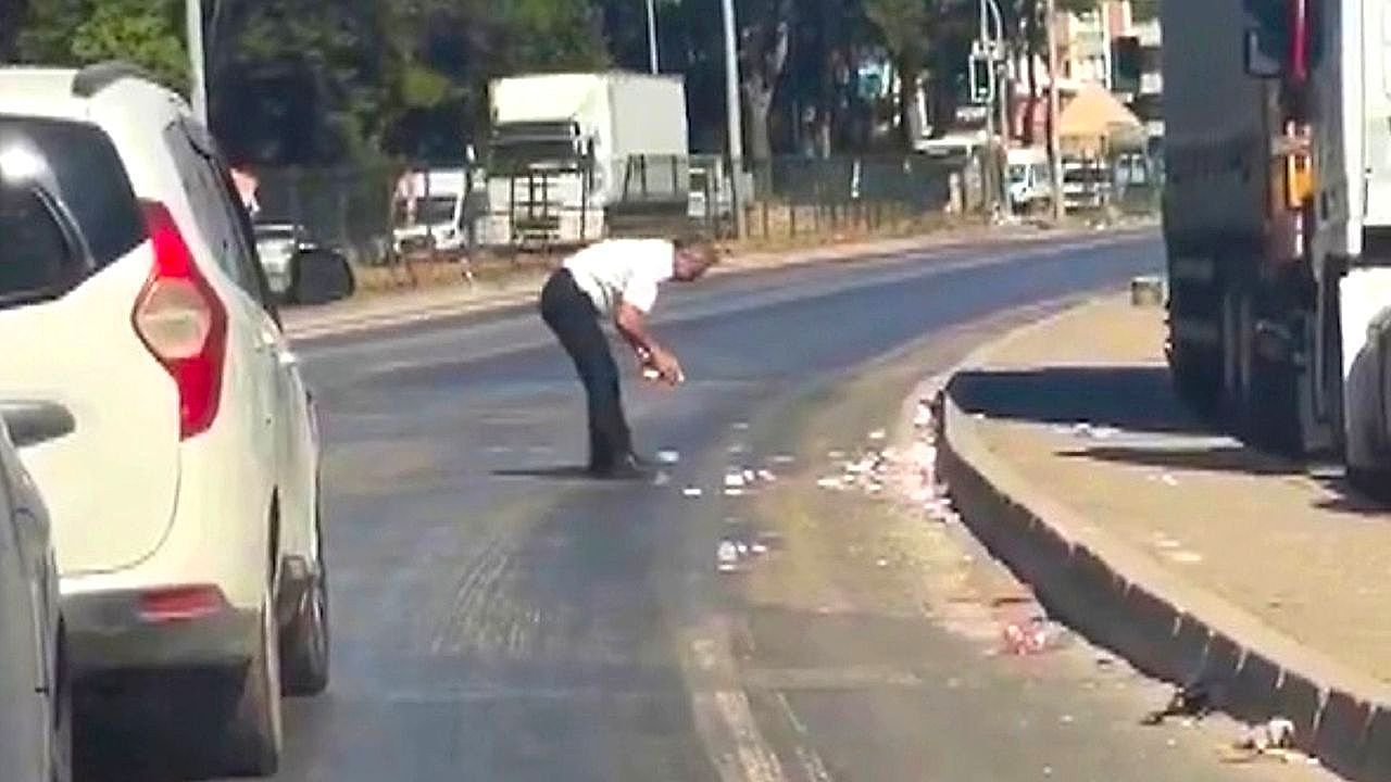 Video: Two men dart into traffic to rescue thousands in cash blown across highway