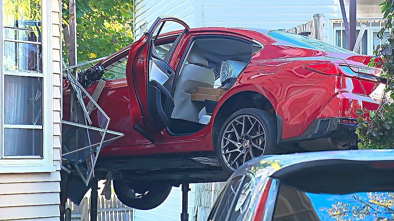 Speeding car smashes into Boston home and ends up dangling in midair